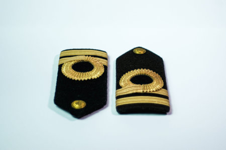 A pair of epaulette gold bar second officers, isolated on white opposite top and bottom front view