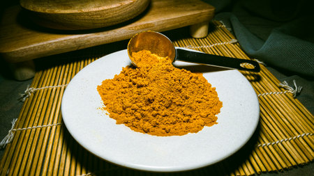 Dried Turmeric powder on a white plate angled viewの写真素材