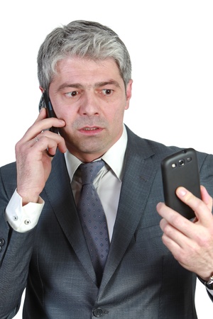 Businessman talking simultaneously on two cell phones    under pressure   の写真素材