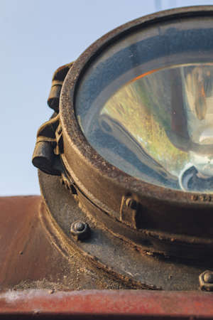 Fragment of old train headlight. Old rusty locomotive, close up.の写真素材