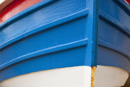 a close up of the prow of a brightly painted traditional small fishing boatの写真素材