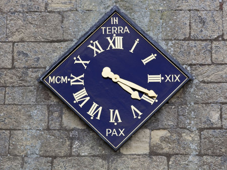 an unusually shaped gilded clock on a stone wall