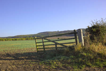 field gate with fields and tree covered hillsides in autumnの写真素材