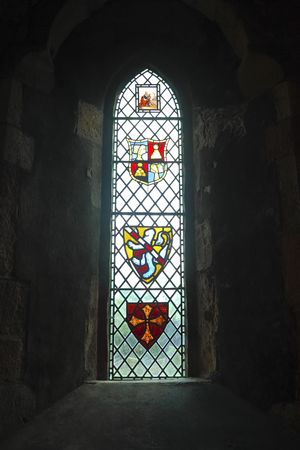 heraldic stained glass in the window of an ancient rural churchの写真素材
