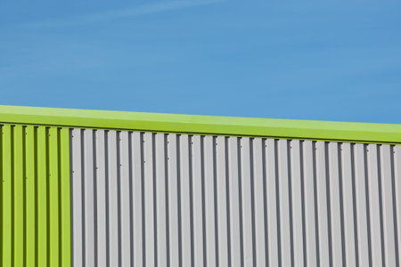 a modern brightly colored business unit against a clear blue skyの写真素材