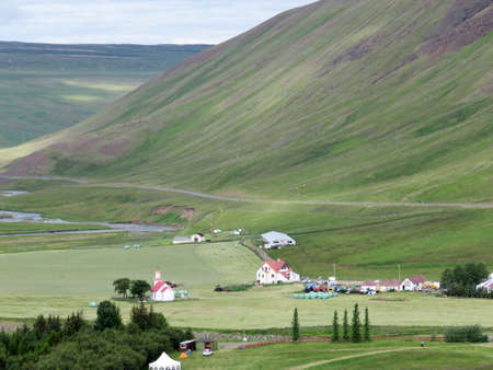 Landscape of North Iceland Showing Red Roof Church, Green Pasture and Green Mountain in Blonduos, Iceland, July 11, 2017のeditorial素材