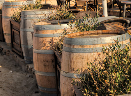Old wooden barrels on a beach in the background a cafe