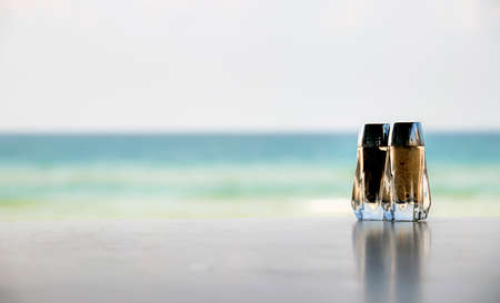 Set of salt and pepper shakers on the background of the seaの写真素材
