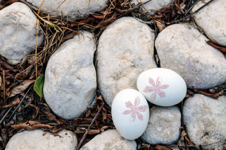 Decorated Easter eggs lie on gray stonesの写真素材