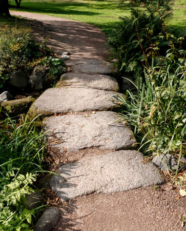 A small bridge of large stones in the green grass in the city paの写真素材