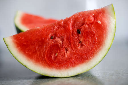 Slice of ripe watermelon on a blurred backgroundの写真素材