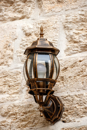 Street lamp on the wall of large blocks of stones