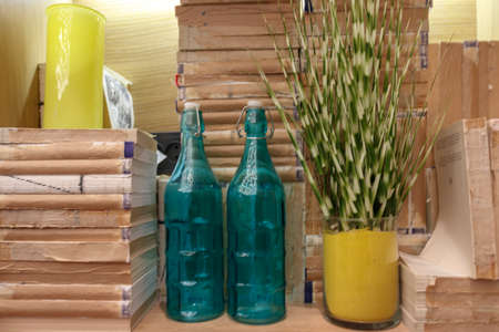 Empty green glass bottles next to books without coversの写真素材
