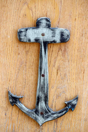 Wooden stylized anchor on a wooden boardの写真素材