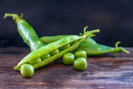 Ripe green pea pods on a wooden board close upの写真素材