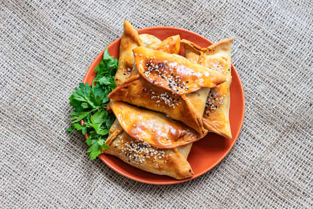 Top view of Samsa . Traditional oriental meat patties with parsley leaves on a plateの写真素材