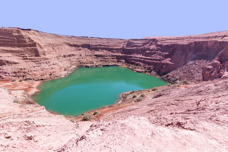 Deep blue Hidden Lake in Timna surrounded by the red cliffs of Eilat. Israel