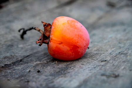 Ripe persimmon fruit close-up on a wooden surface. Georgiaの写真素材