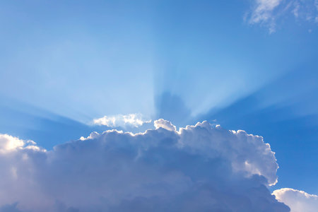 Background of rays of the sun breaking through the clouds in the blue sky