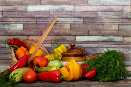 Still life of fresh vegetables on a wooden table against a brick wall. Peppers, zucchini, tomatoes, dill.の写真素材