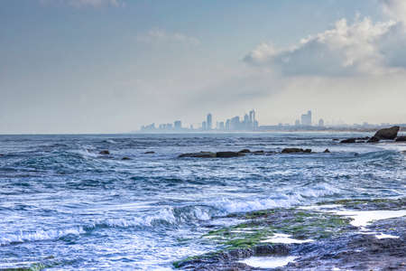 View of the city in the fog from the side of the sea coastの写真素材