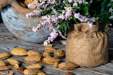 Still life. Almond nuts in a clay pot on a wooden table closeupの写真素材