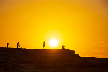 Silhouettes of photographers against the background of the rising sun. Makhtesh Ramon Israel.の写真素材