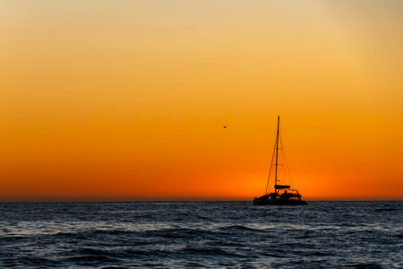 Sea yachts against the background of the sun reflected in the waves. An amazing sunset on the Atlantic Ocean.の写真素材