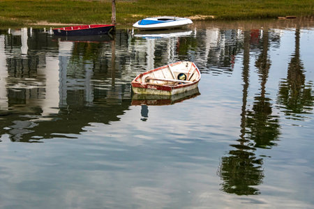 Reflection in the water of fishing boats standing on the pier in the sea bay. South Africa