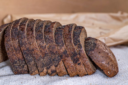 Loaf of sliced fresh rye bread closeup on a kitchen table