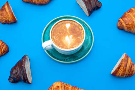 delicious croissants with a cup of coffee with pattern style and blue backgroundの写真素材
