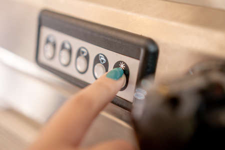 Finger pressing machine button in gray color in close up concept.の写真素材
