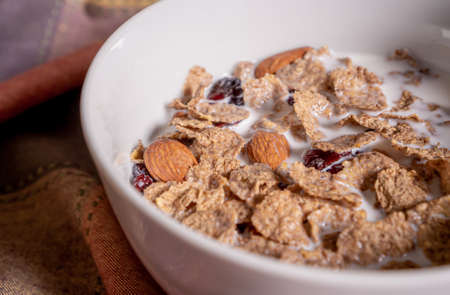 Delicious whole grain cereal dish with milk, almonds, coconut and blueberries on top on a table.の写真素材