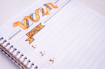 Notebook to write New Year's resolutions on a table with a white tablecloth in close up concept