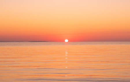 Beautiful sunset beach in orange tones with calm sea waves in Yucatan Mexico.の写真素材