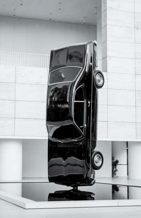 Amazing artwork inside a museum of a car in vertical black color on a base on the ground in black and white concept.のeditorial素材