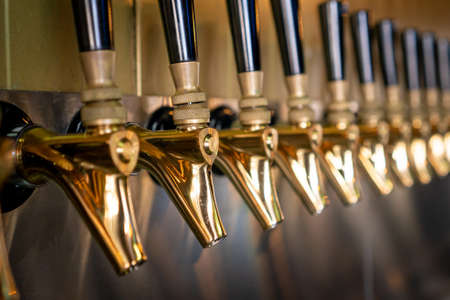 Innovative gold-colored beer taps with black handleの写真素材