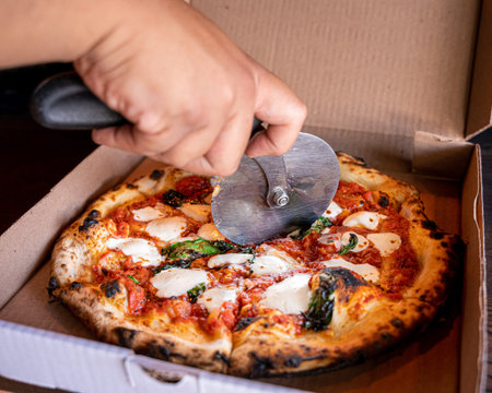 Exquisite Margarita pizza with fresh Italian ingredients in a pizza box ready for delivery.の写真素材