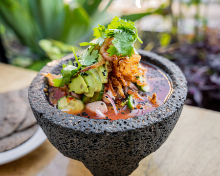 delicious mexican agua chile rojo with shrimp, squid, octopus and clam prepared with red chiles and...