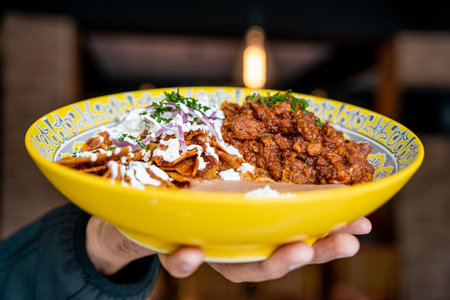 delicious red chilaquiles, beans and red pork chicharron, traditional mexican dish.の写真素材