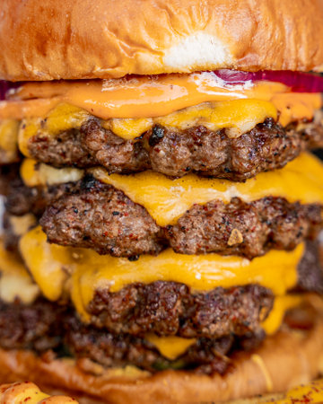 Giant five-meat cheeseburger on a delicious bunの写真素材