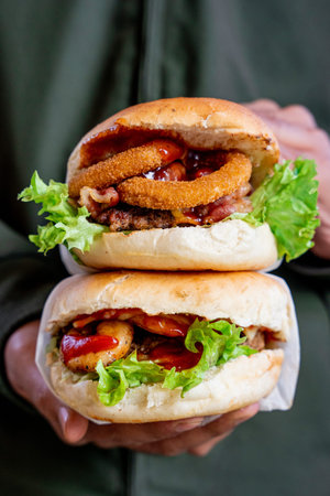 person holding two delicious crispy chicken burger with vegetables