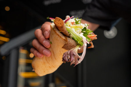 Delicious meat gyro with vegetables inside a restaurantの写真素材