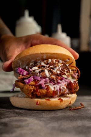 Delicious fried chicken style crispy chicken burger with BBQ, inside a food kitchen, crispy chicken, fresh ingredients.の写真素材