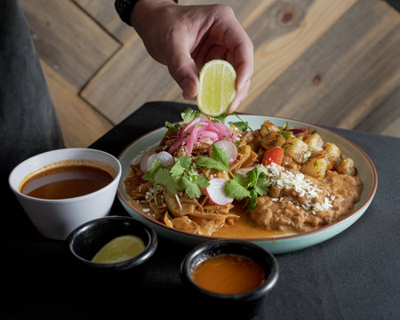 Delicious chilaquiles with Mexican style birria accompanied by beans, inside a Mexican restaurant.の写真素材