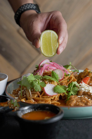 Delicious chilaquiles with Mexican style birria accompanied by beans, inside a Mexican restaurant.