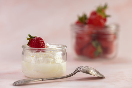 Strawberries in a glass jar on a pink background