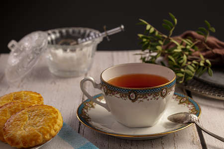 Cup of tea with biscuits on a white wooden tableの写真素材