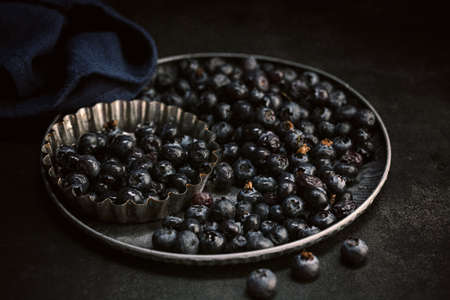 Raw blueberries in a tray on a dark backgroundの写真素材