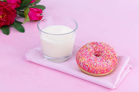 Pink donut with a glass of milk on a pink backgroundの写真素材